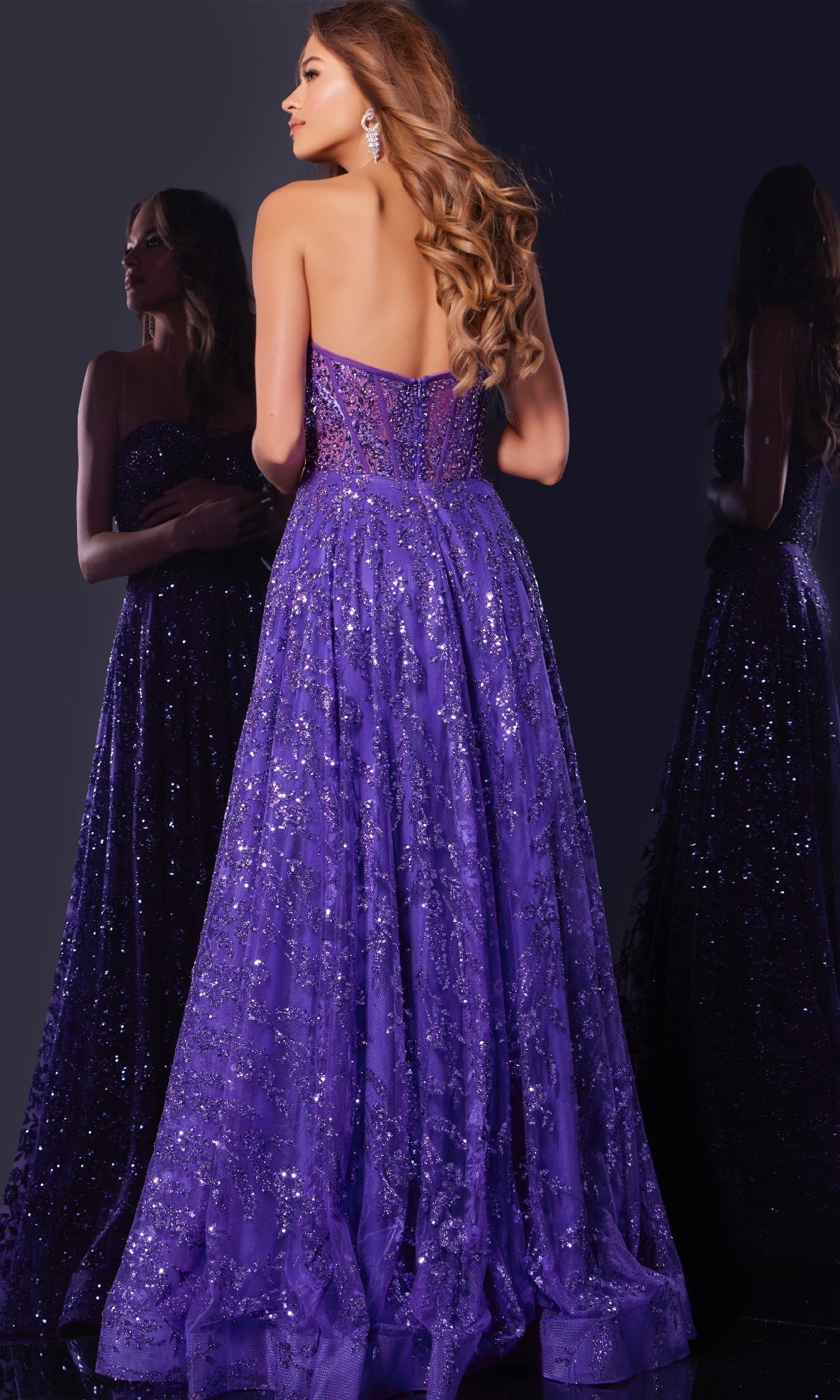 A woman with long wavy hair wears the Jovani 37413 long prom dress featuring sequins and a strapless corset bodice, standing before a mirror against a dark background.